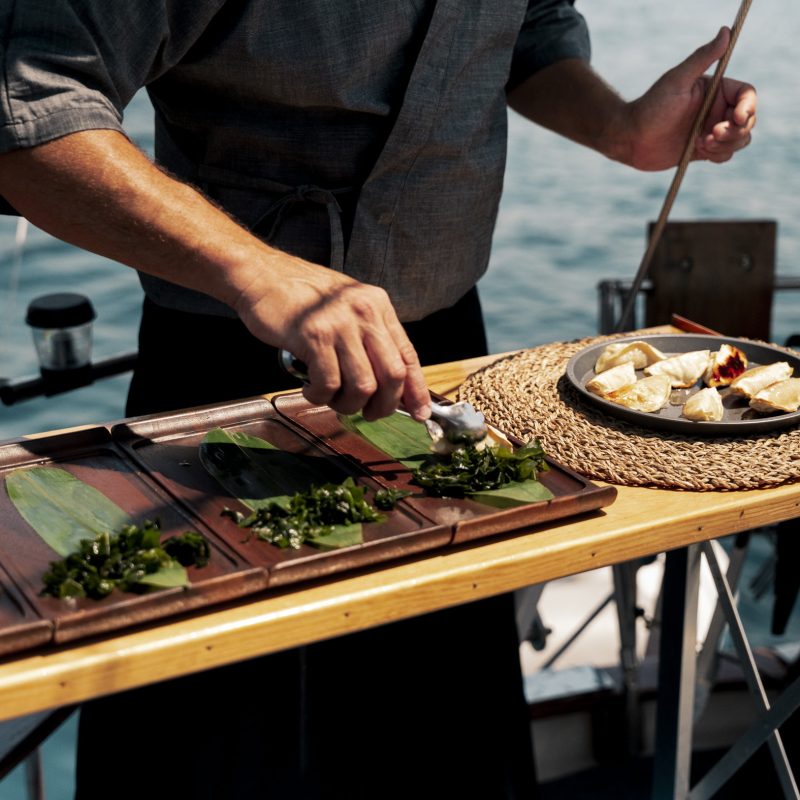Chef cooking live on deck during a gastronomic sailing experience