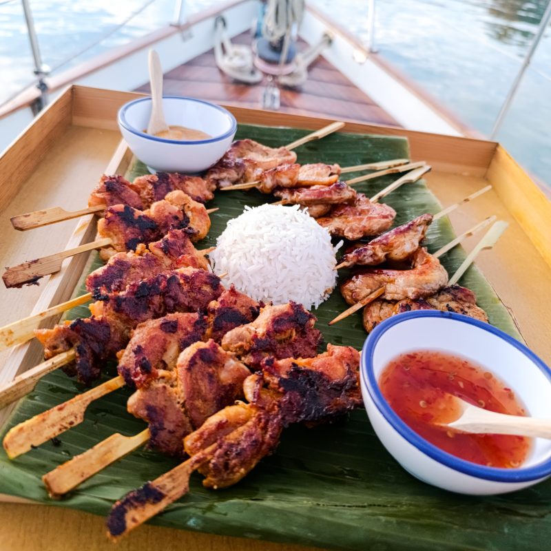 Gourmet skewers with rice served on board a classic sailboat